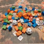 Fiches, meeples en dobbelstenen van Root op het bord.