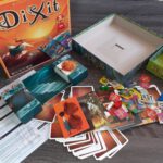 De doos en inhoud van Dixit Odyssey, op display.