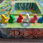 De doos van Dixit opgezet om punten bij te houden, met konijnmeeples als puntentellers.