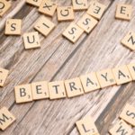 Scrabbleletters spellen het woord 'betrayal'
