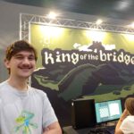 Finn Schuuring poseert voor zijn banner van King of the Bridge op Gameforce 2024