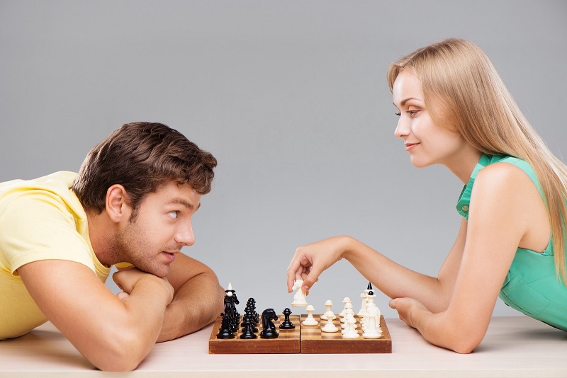 Een man en vrouw nemen het tegen elkaar op in een potje Schaken. De wonderen zijn de wereld nog niet uit.