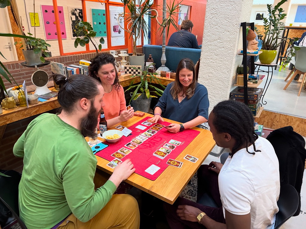 Een groepje van vier speelt samen een potje River Rats rondom een tafel