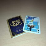 Het spelregelboekje naast de klaver drie van het deck