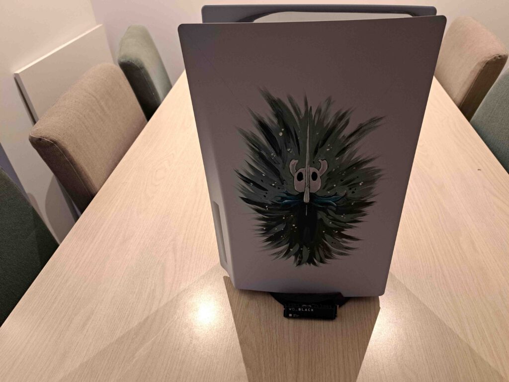 Mijn PlayStation 5 staat op tafel, met verlichting die per ongeluk een stuk dramatischer is dan bedoeld