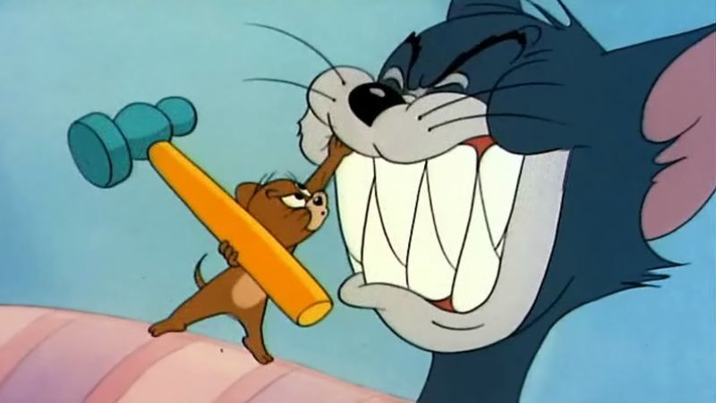 Jerry staat op het punt Tom een mep te geven met een hamer. Een screenshot uit de Tom & Jerry cartoon.