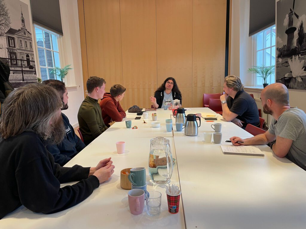 Ik zit aan het hoofd van een tafel tijdens de sessie 0 workshop in de bibliotheek.