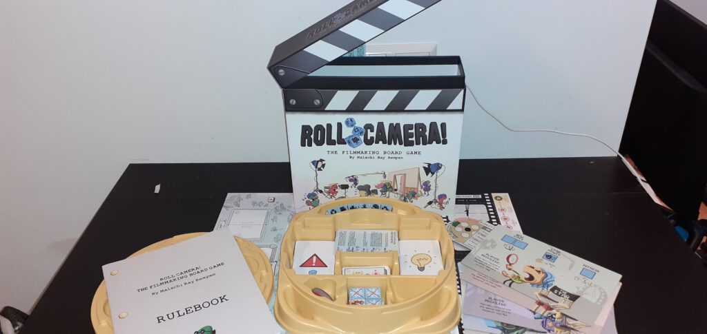 De doos en spelonderdelen van Roll Camera